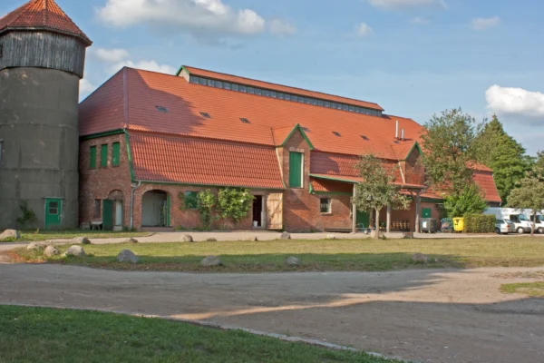 Historisches Hofgebäude von Gut Wulksfelde mit Backsteinfassade, rotem Dach und Siloturm.